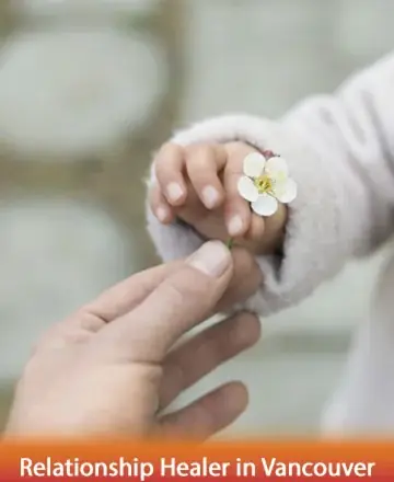 A tender moment unfolds as a tiny hand reaches out, gently holding a delicate flower, symbolizing innocence and trust. This serene image evokes warmth and connection, inviting a sense of peace and understanding. Relationship healer in Vancouver.